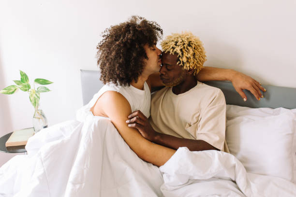 coppia gay etnica che si lega nella loro camera da letto - couple black american culture kissing foto e immagini stock
