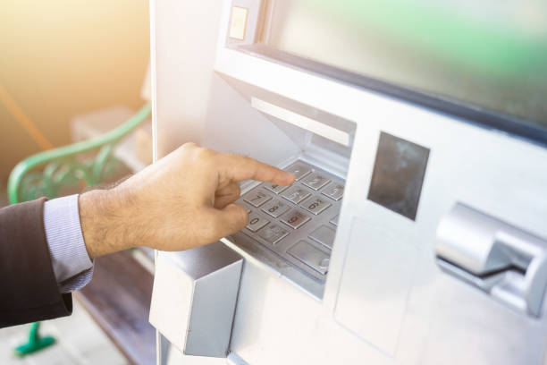 istock Close up male hand using atm machine withdrawal money. Man put the pin code into bank machine to take the money. 1339055490
