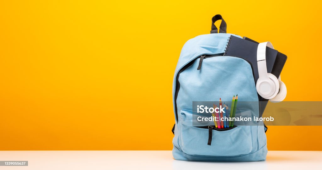 Back to school background. Stationery Supplies in the school bag. Banner design education On Yellow background. Backpack Stock Photo