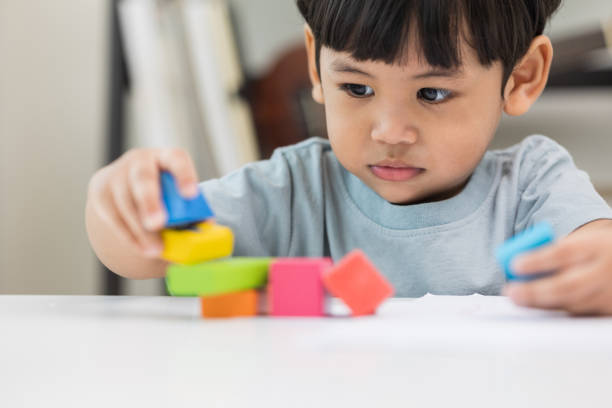 istock Asian little boy education from home. Developing children's learning before entering kindergarten Practice the skills of playing with wooden toys in living room. 1339055697