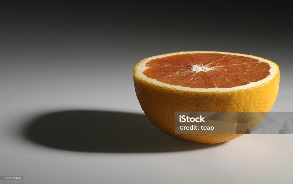 Half of orange Side view of a half orange set on dark background, shadows included. Backgrounds Stock Photo