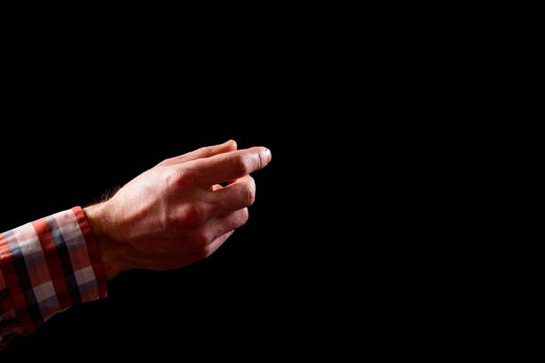 istock Male hand isolated on black. Helping hand. Hand picking on black with copy space. 1339064986