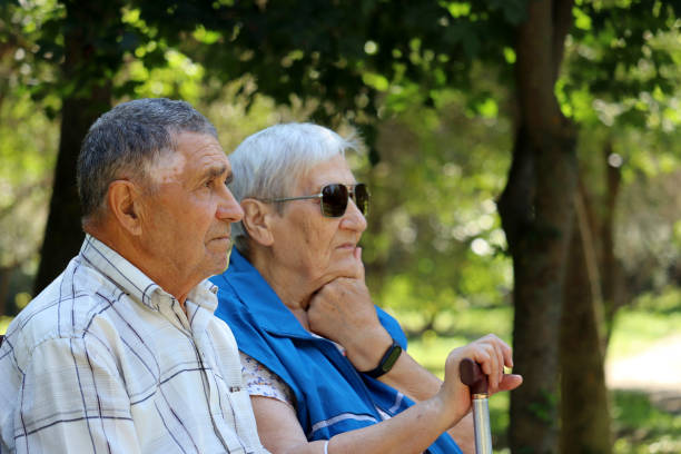 istock Elderly couple sitting on a bench with thoughtful faces expression 1339066278