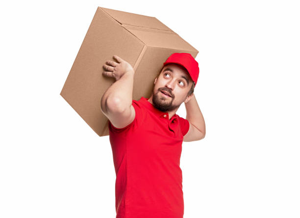 istock Delivery man carrying cardboard box 1339066680