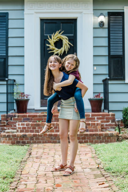 istock A father holding his 10 year old daughter piggyback on his back while outside 1339068039