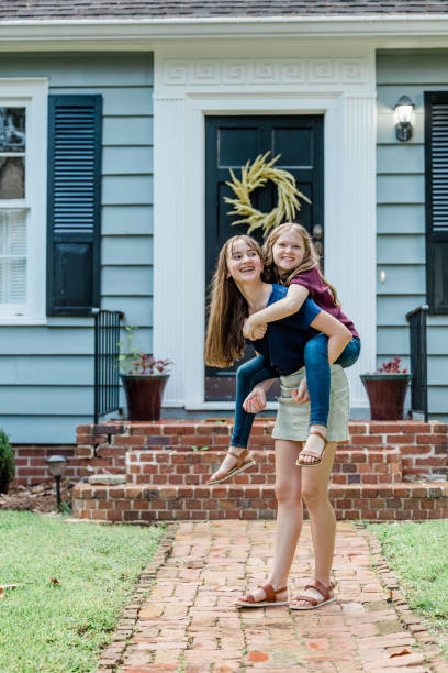 istock A father holding his 10 year old daughter piggyback on his back while outside 1339068194