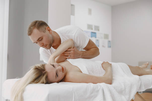 istock Male physiotherapist massaging woman's back 1339068270