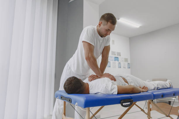 istock Male physiotherapist massaging man's back 1339068374
