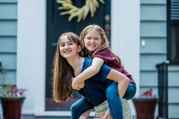 istock A father holding his 10 year old daughter piggyback on his back while outside 1339068439