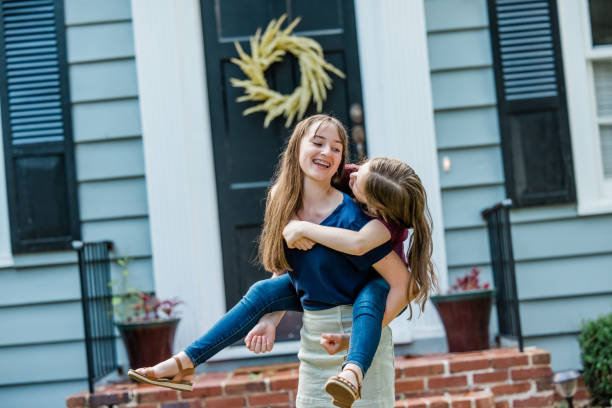 istock A father holding his 10 year old daughter piggyback on his back while outside 1339069239