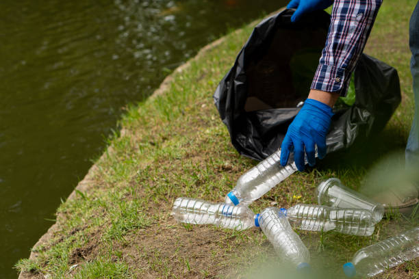 istock Young man picking up trash bottles Plastic in the park to clean the environment 1339070304