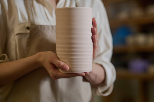 istock Hands of a potter with a newly made pot 1339078593