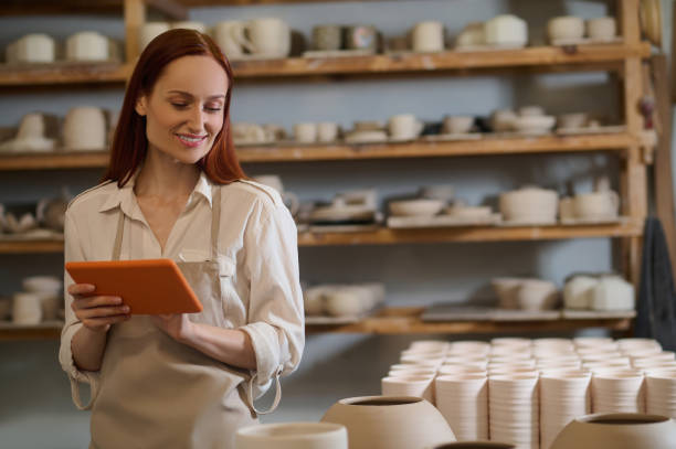 istock A cute young female potter with a tablet in hands 1339078696