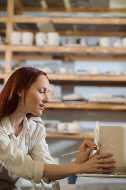 istock A pretty woman looking involved while painting the pot 1339078719