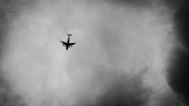 istock Airplane flying through the drak clouds 1339079605