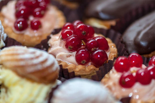 Close-up of a cupcake with cream and fruits. Red Currant (Red Cherry).