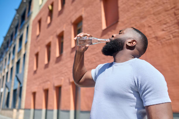 istock A dark-skinned man in a white tshirt walking in the street 1339085158