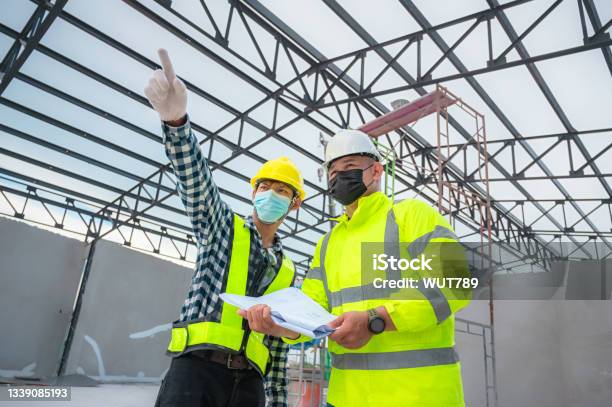 Civil Engineer Inspect Structure At Construction Site Against Blueprint Building Inspectors Jointly Inspect The Building Structure With Civil Engineer Civil Engineer Hold Blueprint Inspect Building Stock Photo - Download Image Now
