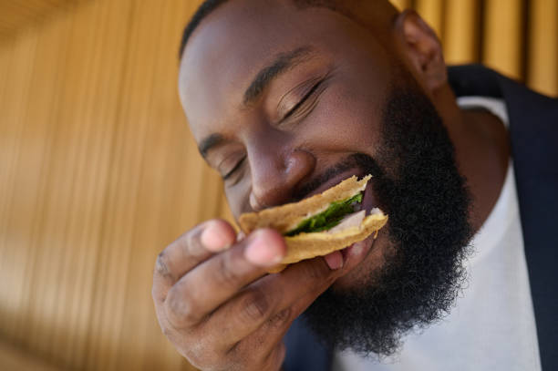 A dark-skinned maneating snadwich with a big appetite stock photo