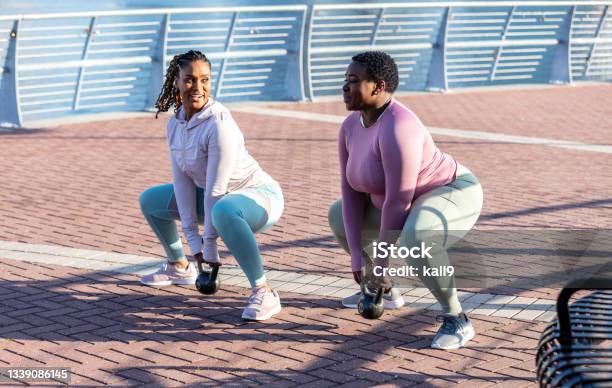 African-American women in city exercising, kettlebells
