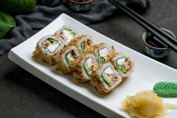 istock Roll Bonito with salmon on white plate on dark stone table 1339086249