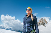 Happy cheerful laughing young female in climbing harness and sunglasses outdoor portrait while they descending after a successful mountain top climbing. Happy active people image near Aiguille du Midi