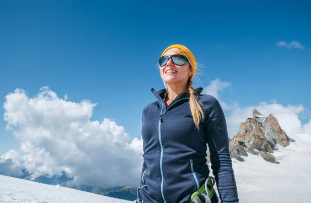 happy cheerful laughing young female in climbing harness and sunglasses outdoor portrait while they descending after a successful mountain top climbing. happy active people image near aiguille du midi - skiing snow sport mountain imagens e fotografias de stock