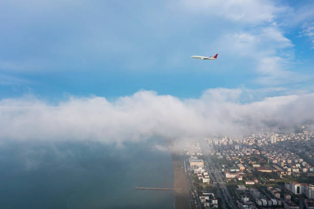 istock Passenger airplane flying over city. 1339086991