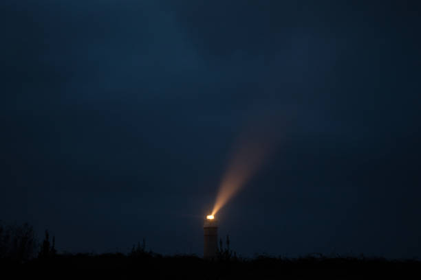 istock lighthouse with light on reflecting in the fog 1339087011
