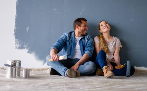 pareja amorosa divirtiéndose renovando su casa y pintando las paredes - decoración objeto fabricado fotografías e imágenes de stock