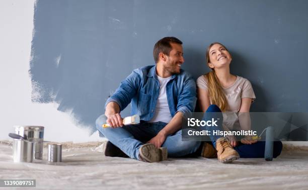Loving Couple Having Fun Renovating Their House And Painting The Walls Stock Photo - Download Image Now