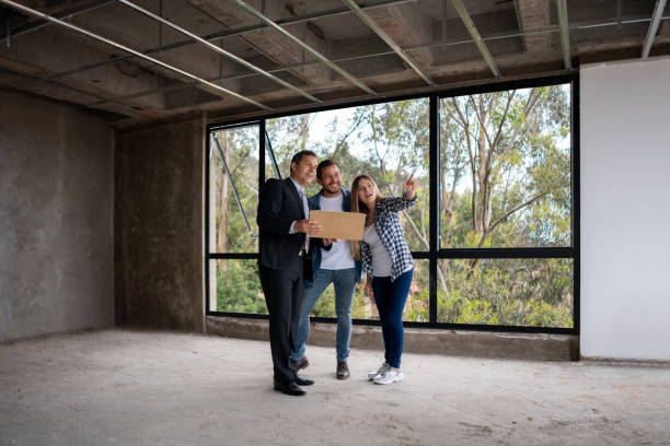 istock Couple looking at a house under construction with the architect 1339089763