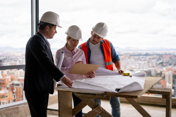 istock Team of workers at a construction site working together and looking at blueprints 1339089776
