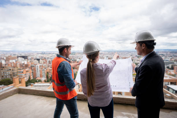 istock Team of workers looking at blueprints at a construction site 1339089817