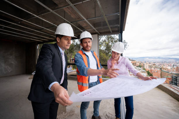 istock Team of building contractors looking at blueprints at a construction site 1339089819