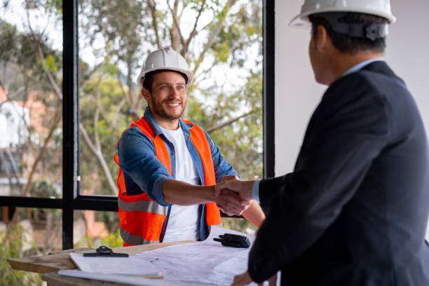 istock Building contractor greeting the civil engineer with handshake at a construction site 1339089824