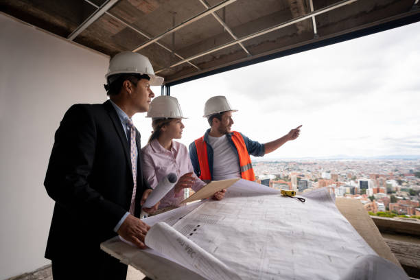 istock Construction team discussing ideas about a blueprint at a building site 1339089901