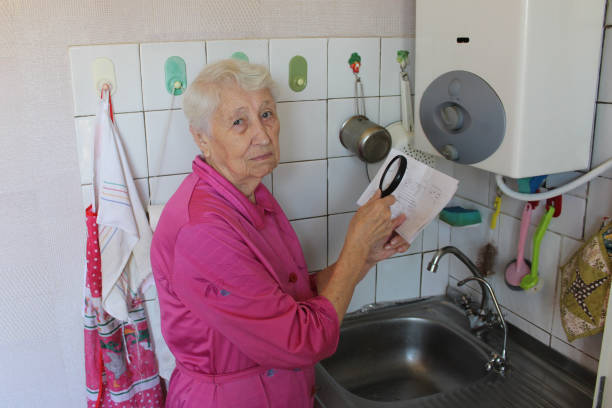 la femme âgée à la maison et examine la facture de gaz - flame natural gas boiler burner photos et images de collection