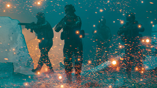 Soldiers in a platoon make an attack with rifles at night. Sparks fly through the air as the men move forward.  Digitally generated image.
