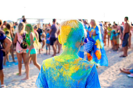 Young teenager at the festival of colors. Holi Indian Colors Festival. Digital detox, lifestyle, outdoor activities