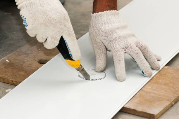 istock Cutting a hole for the lamp with a knife. 1339100660