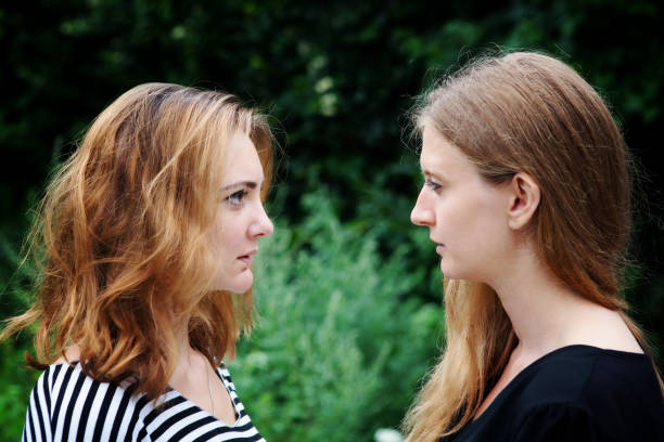 istock two beautiful young women standing outdoors and looking at each other 1339103276