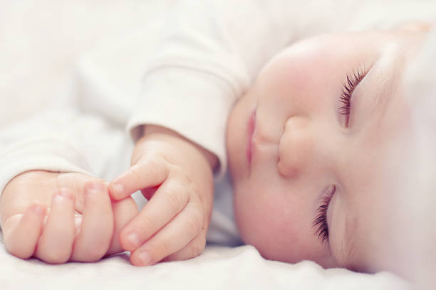 のクローズアップのポートレート、白で赤ちゃん美しいベッドルーム - 赤ちゃん　睡眠 ストックフォトと画像