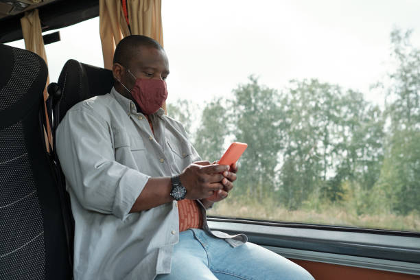 istock Black Man In Mask Riding Bus 1339106480