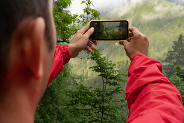 istock Hand taking photo of scenic mountain view 1339106551
