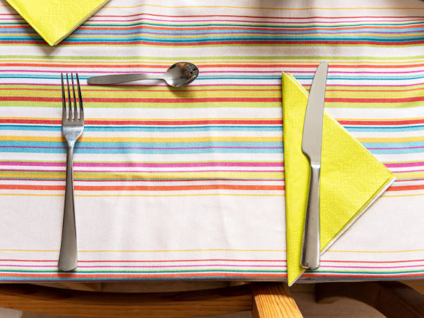 istock Cutlery on the table almost ready for the meal, objects top view, from above, closeup, nobody. Preparing the table concept, no plate, copy space in the middle. Fork, knife and a little spoon 1339106852