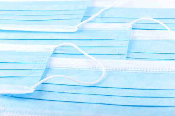 istock Multiple plain simple blue protective medical anti viral face masks set, abstract background texture. Lots of face masks laying on a flat surface, creative backdrop. Covid 19, corona virus protection 1339107050