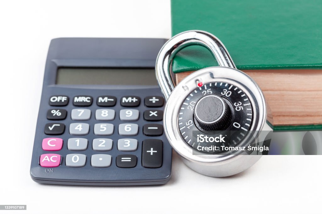 Simple calculator, coded padlock and a closed book, math textbook on the table, cryptography study class course, studying cryptology, data encryption cipher mathematics, abstract concept, nobody Book Stock Photo