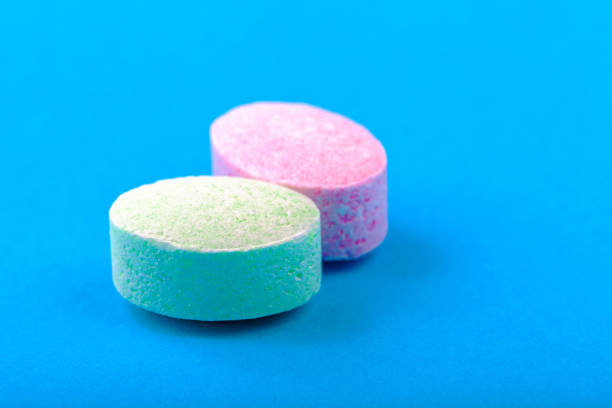 Various pills and capsules lie on the table.