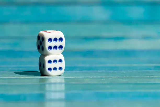 Photo of Two small little game dice showing six on top of each other, stacked tiny dice with number 6 on them, closeup. Winning, success, luck and good great odds simple abstract concept, lucky throw, nobody